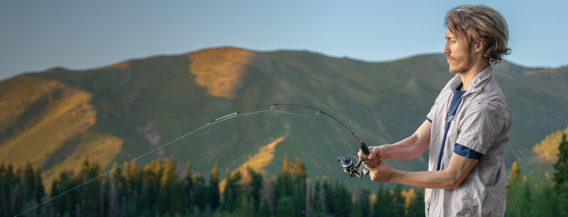 Angler holding an Ugly Stik Camo Dock Runner spinning combo